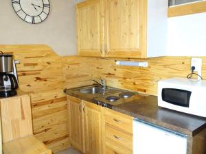 a kitchen with a sink and a clock on the wall at Residence Albion - Agréable petit studio offrant une belle vue dégagée ! MAE-7564 in Aix-les-Bains +4 photos