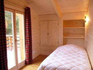 een slaapkamer in een blokhut met een bed en een raam bij Chalet - Chalets 494 in Lans-en-Vercors