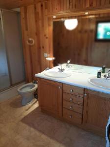 a bathroom with two sinks and a toilet and a television at Chalet - Chalets 494 in Lans-en-Vercors