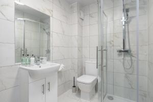 a white bathroom with a toilet and a shower at 4bed perfect for contractors & Long Stays By Valore Property Services in Milton Keynes