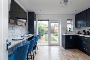 ミルトン・キーンズにある4bed perfect for contractors & Long Stays By Valore Property Servicesのキッチン(青いキャビネット、青い椅子付) +33枚の写真