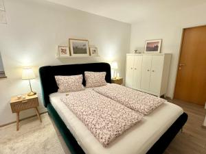 アンベルク・イム・ランマータールにあるHelle Ferienwohnung Saunahausのベッドルーム1室(大型ベッド1台、黒いヘッドボード付)