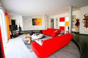 ein Wohnzimmer mit roten Möbeln und einem roten Sofa in der Unterkunft Villa Occitanie - Maisons & Villas pour 6 Personnes 084 in La Grande-Motte