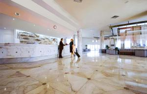 dos personas de pie en el vestíbulo de un edificio en Monarque El Fatimi Mahdia, en Mahdia