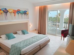 ein Hotelzimmer mit einem Bett und einem großen Fenster in der Unterkunft Monarque El Fatimi Mahdia in Mahdia
