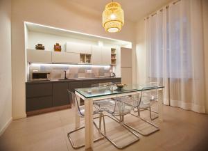 uma sala de jantar com uma mesa de vidro e cadeiras em Le robbiane 44 - 46 em Florença