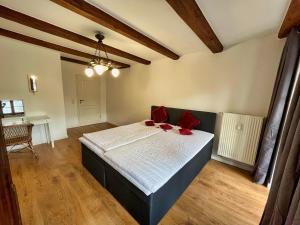 Un dormitorio con una cama con almohadas rojas. en großzügige Wohnung in der Altstadt mit Balkon, en Görlitz
