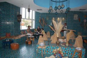 a room with blue walls and people sitting in it at Monarque El Fatimi Mahdia in Mahdia