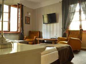 a room with chairs and a table and a tv at Leśny Dworek in Wyszków