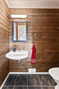 a bathroom with a white sink and wooden walls at Hytte Stryn skisenter in Stryn