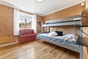 Hytte Stryn skisenter في سترين: غرفة نوم مع سرير بطابقين وكرسي احمر