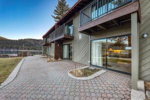 a house with a patio next to a lake at Quiant Studio w/Lake View #144 at Donner Lake Village in Truckee