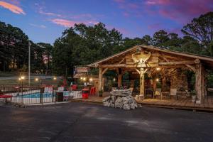 a wooden gazebo in front of a pool at Stonegate Lodge King Bed WIFI 50 in Roku TV Salt Water Pool Room # 101 in Eureka Springs