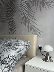 1 dormitorio con 1 cama con un mural de hojas tropicales en APARTAMENT CENTRUM, en Nowe Miasto Lubawskie