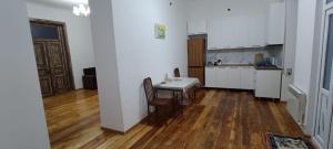a kitchen with white walls and a wooden floor at Ganja hause in Ganja