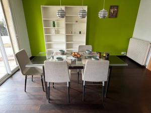 uma sala de jantar com uma mesa de vidro e cadeiras em Rêve cosy - Arceaux * Spacieux F3 * proche tram * wifi * parking em Montpellier