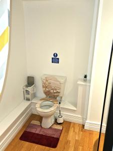 a bathroom with a toilet with a sign on the wall at LONDON HEATHROW GLAMOUR MANSION HOUSE in Uxbridge