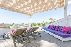 een terras met een bank en stoelen bij Villaflair - Marbella Sea View in Marbella