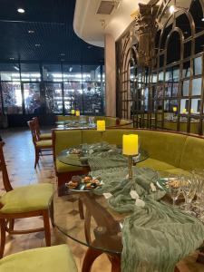 un restaurante con sofás y mesas con platos de comida en Хотел Ботевград en Botevgrad