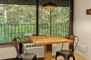 a table and chairs in front of a large window at Stonegate Lodge King Bed WIFI 50 in Roku TV Salt Water Pool Room # 101 in Eureka Springs