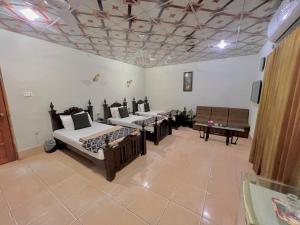 una habitación con 4 camas y un piano en ella en Step inn Guest House Sukkur, en Kalar Goth