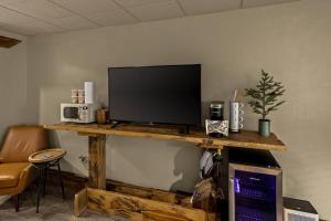 a flat screen tv sitting on top of a wooden table at Stonegate Lodge King Bed WIFI 50 in Roku TV Salt Water Pool Room # 101 in Eureka Springs