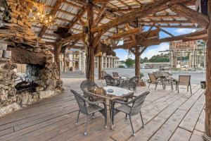 a patio with tables and chairs and a stone fireplace at Stonegate Lodge King Bed WIFI 50 in Roku TV Salt Water Pool Room # 101 in Eureka Springs