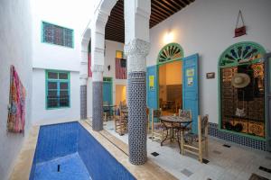 a house with a courtyard with a table and chairs at BackHome Fez in Fez