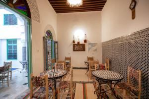 una stanza con tavoli e sedie in un edificio di BackHome Fez a Fes