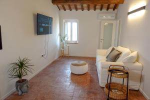 sala de estar con sofá blanco y mesa en CASA NINETTA GUEST HOUSE, en Urbisaglia