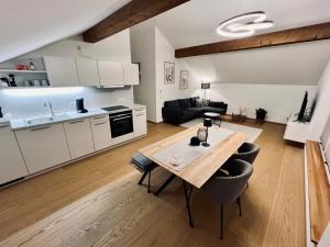 a kitchen and living room with a table in a room at Ferienwohnung zum Kalmbach in Kochel