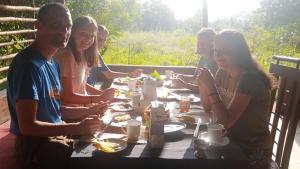 a group of people sitting at a table eating food at Sigiriya Rock Gate Resort in Sigiriya