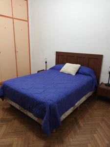 una camera con letto e piumone blu di Alquiler temporario en caballito para 6 personas a Buenos Aires