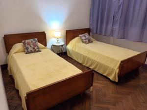 2 letti in una piccola camera con lampada di Alquiler temporario en caballito para 6 personas a Buenos Aires