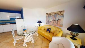 ein Wohnzimmer mit einem gelben Sofa und einem Tisch in der Unterkunft Résidence Victoria Beach - 2 Pièces pour 4 Personnes 954 in Menton