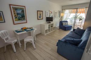 een woonkamer met een blauwe bank en een tafel bij Résidence Le Diplomat - Studio pour 3 Personnes 894 in Menton