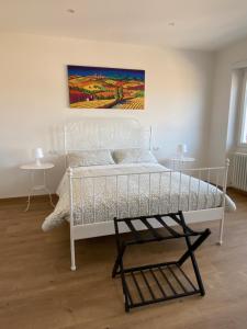 una camera con un letto bianco e un dipinto sul muro di Appartamento vista lago a Bracciano