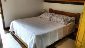 a bedroom with a bed with a white bedspread at Clima Montanhês in Núcleo Mauá