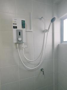 y baño con ducha y manguera. en EasyStay Kampar (near UTAR) 5bedrooms 10pax Free WiFi, en Kampar