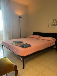Schlafzimmer mit einem Bett mit rosa Bettwäsche und einer Lampe in der Unterkunft La casa di Alberto in Riva Ligure
