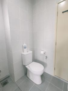 y baño blanco con aseo y ducha. en EasyStay Kampar (near UTAR) 5bedrooms 10pax Free WiFi, en Kampar