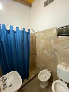 a bathroom with a blue shower curtain and a sink at La Casona de Susana in Colón