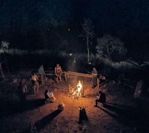 a group of people sitting around a fire at night at ANGELSNESTMOUNTAINVIEW in Chegāt