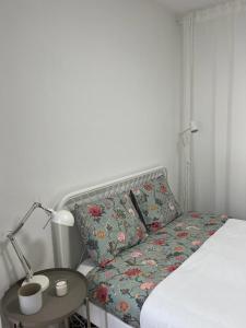 a bed with a pillow and a table with a lamp at Alto Guest room in Lousã