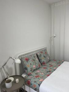 a bed with a pillow and a table with a lamp at Alto Guest room in Lousã +3 photos