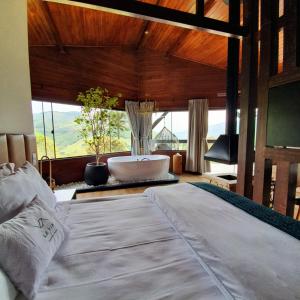 a bedroom with a large bed and a bath tub at Vivenda Le Vin em Alfredo Wagner in Barracão