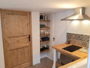 a kitchen with a wooden door and a stove at Private apartment within 15th century farmhouse in Arles-sur-Tech