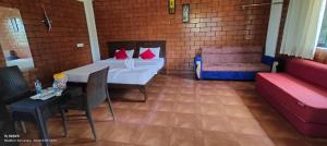 a room with a bed and a table and a couch at Estet stay with pool in Madikeri