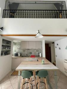 a kitchen with a wooden table and three green chairs at La Casa di Brunina - Serenità a un passo dal Centro in Monza