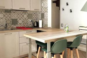 a kitchen with a wooden counter and green chairs at La Casa di Brunina - Serenità a un passo dal Centro in Monza